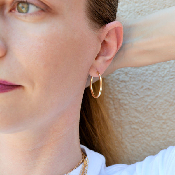 close up of woman's ear showing a 1 inch gold hoop earring